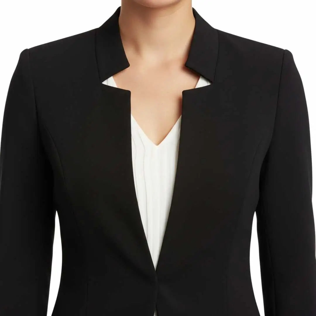 Blazer Feminino Alfaiataria Preto Corte Slim Acinturado em close do decote, destacando a gola estruturada em V sobre blusa branca