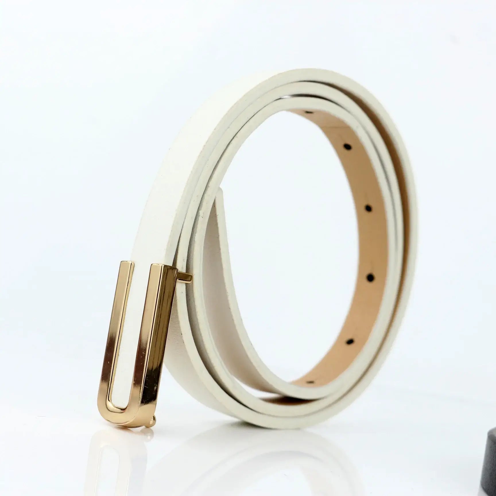 Cinto Feminino Fino de Couro Branco enrolado sobre fundo claro, com fivela dourada retangular