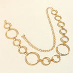 Cinto de Metal Feminino Corrente Dourado disposto em curva, evidenciando a alternância entre argolas grandes e pequenas