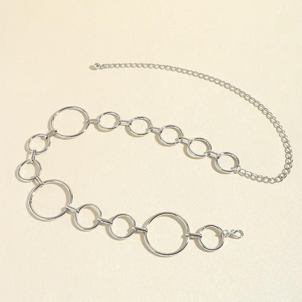 Cinto de Metal Feminino Corrente Prata estendido sobre fundo claro, com a corrente de ajuste na extremidade