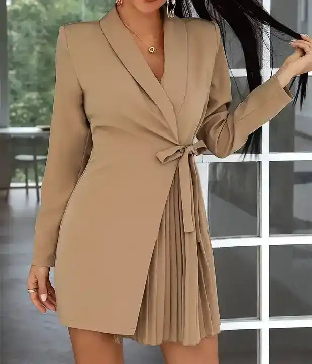 Vestido Blazer Curto Plissado Bege em plano de meio corpo, destacando o laço da faixa e o plissado da saia