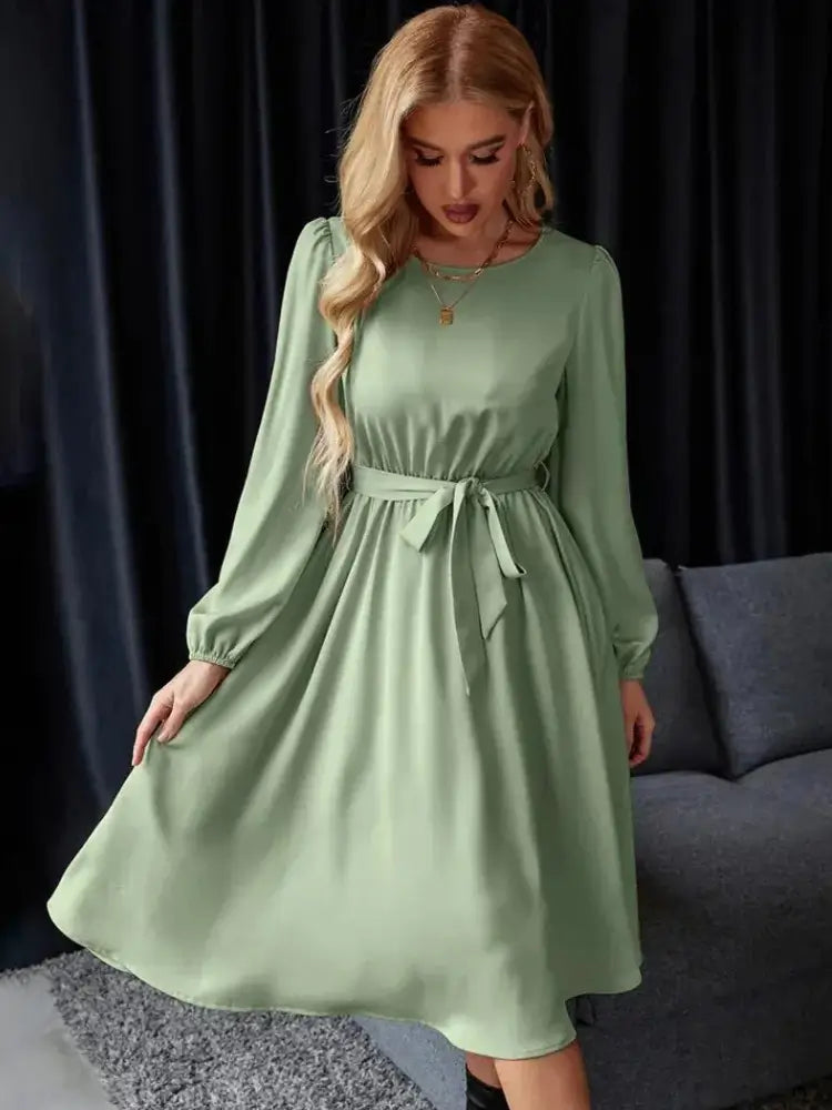 Vestido Casual Midi Manga Longa na cor verde, visto de frente com a modelo segurando a saia rodada