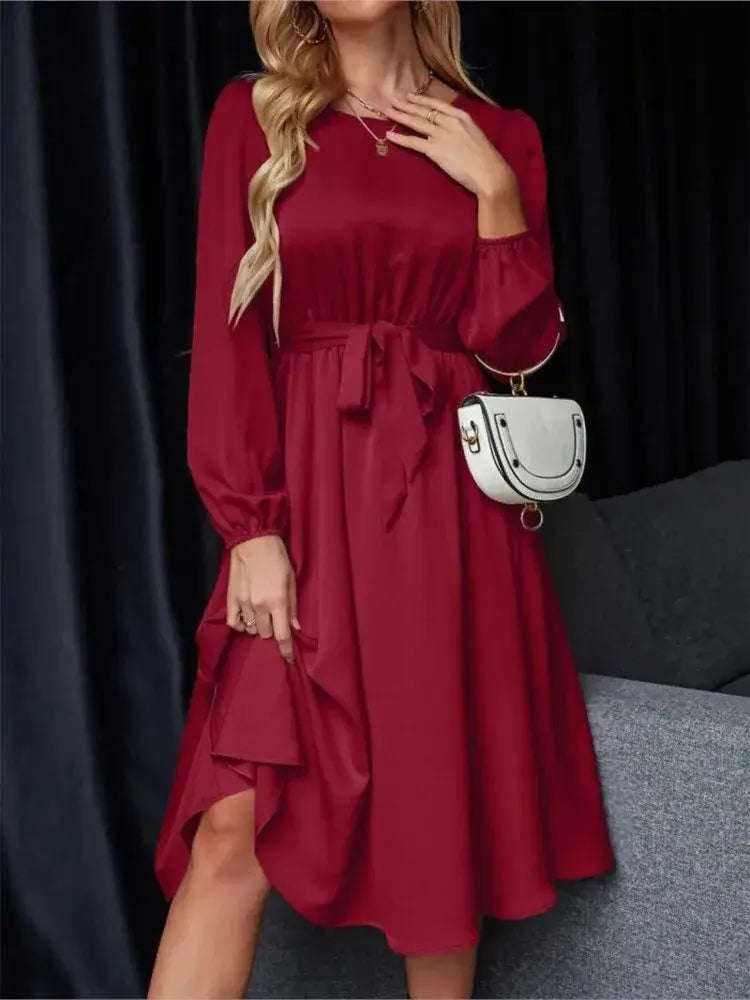 Vestido Casual Midi Manga Longa na cor vinho, visto de frente com bolsa branca a tiracolo e laço na cintura