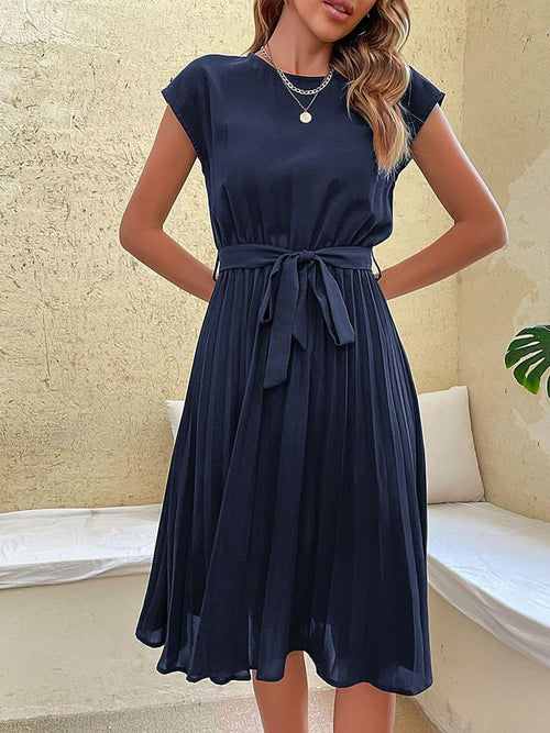 Vestido Casual Midi Plissado Azul Marinho visto de frente, com faixa amarrada na cintura, manga curta e saia plissada