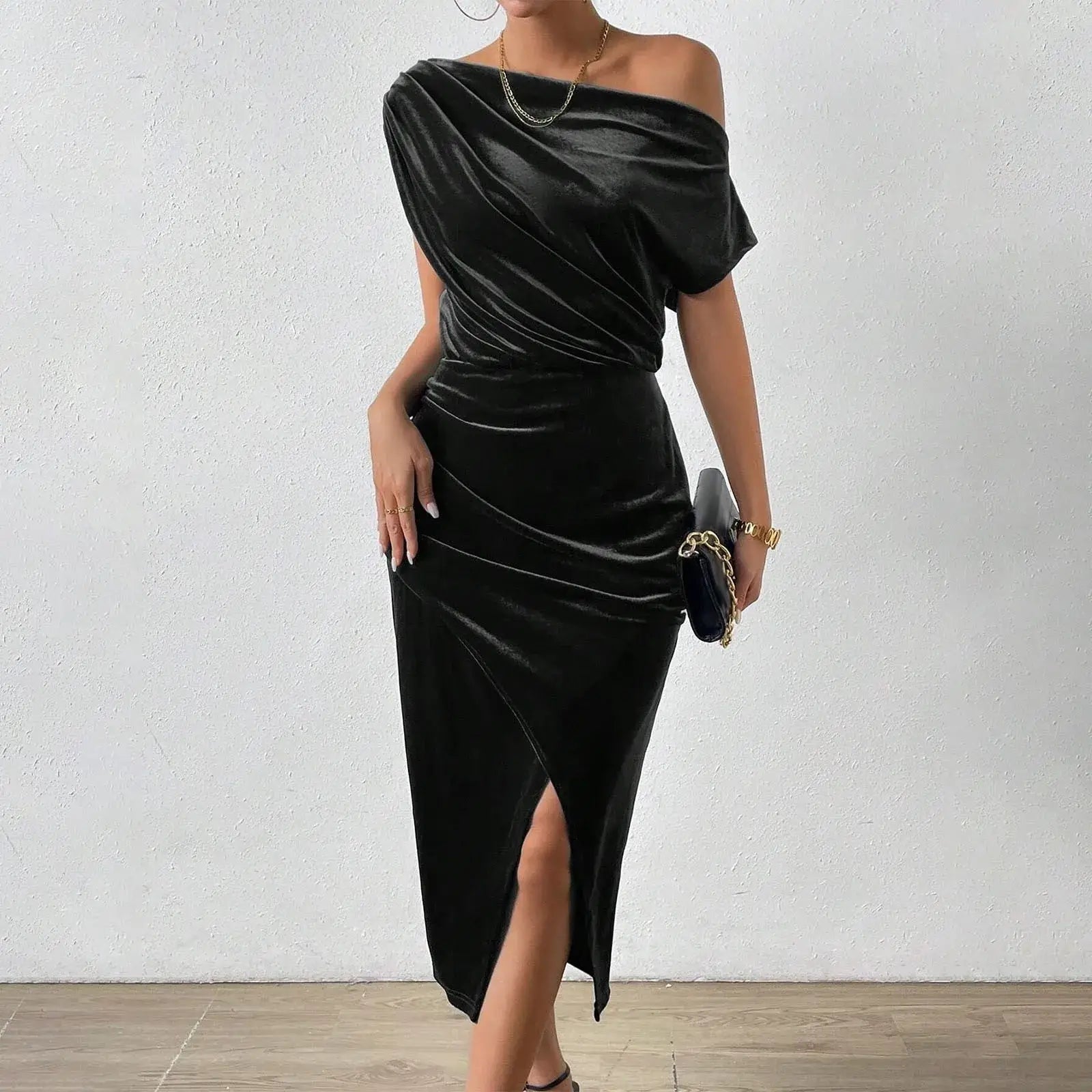 Vestido de Festa Longo de Veludo Sonia preto, visto de frente com bolsa azul de alça corrente e fenda frontal
