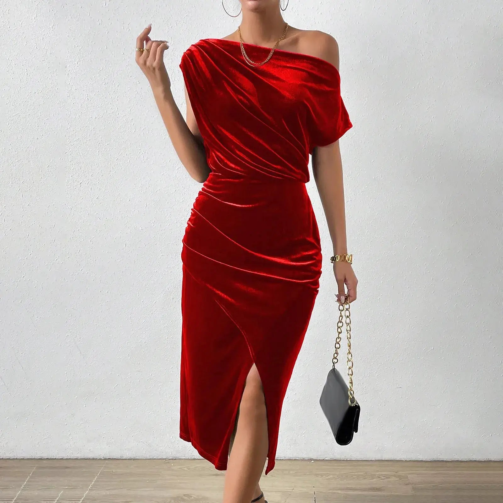 Vestido de Festa Longo de Veludo Sonia na cor vermelha, visto de frente com bolsa preta de alça dourada