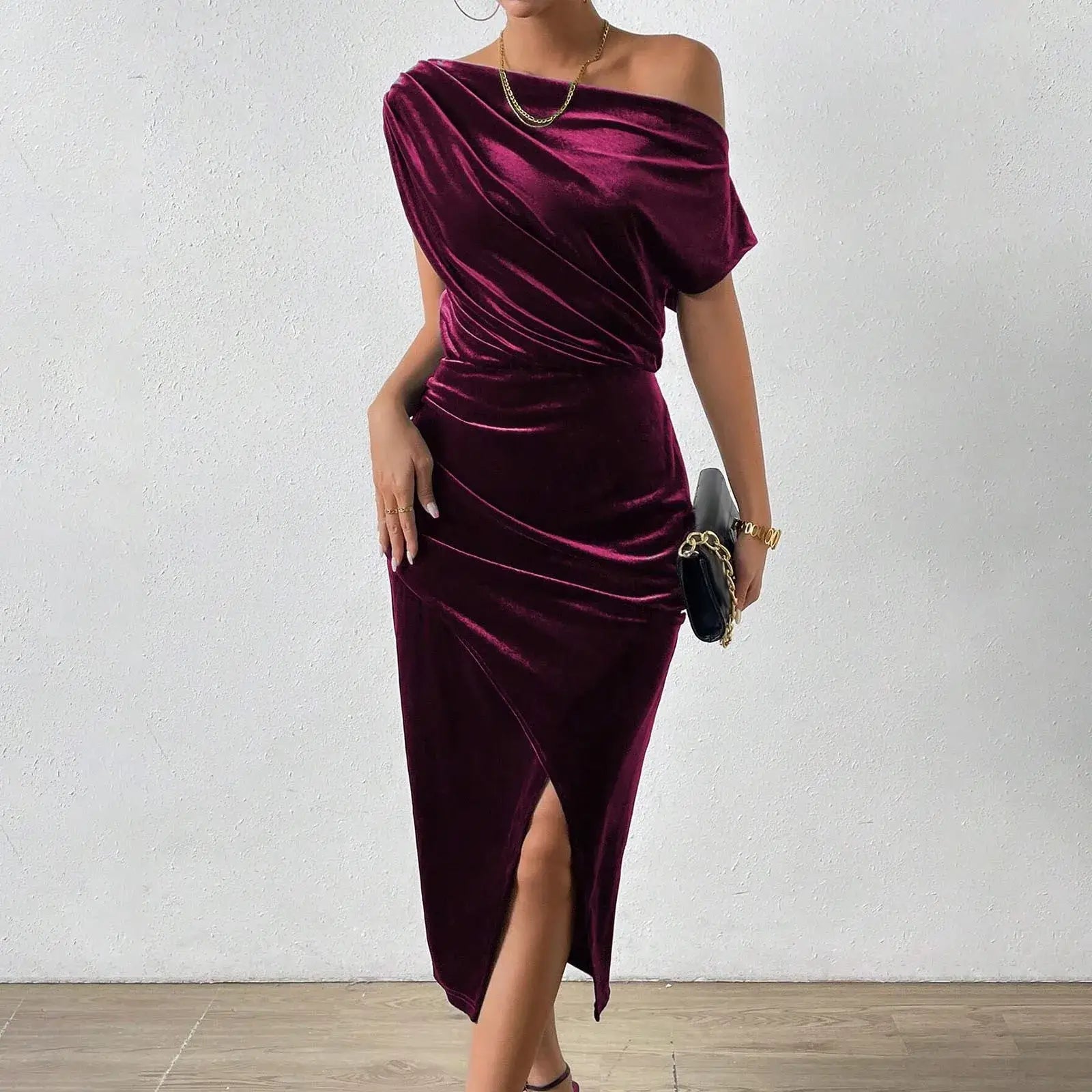 Vestido de Festa Longo de Veludo Sonia na cor magenta, visto de frente com bolsa azul e fenda lateral
