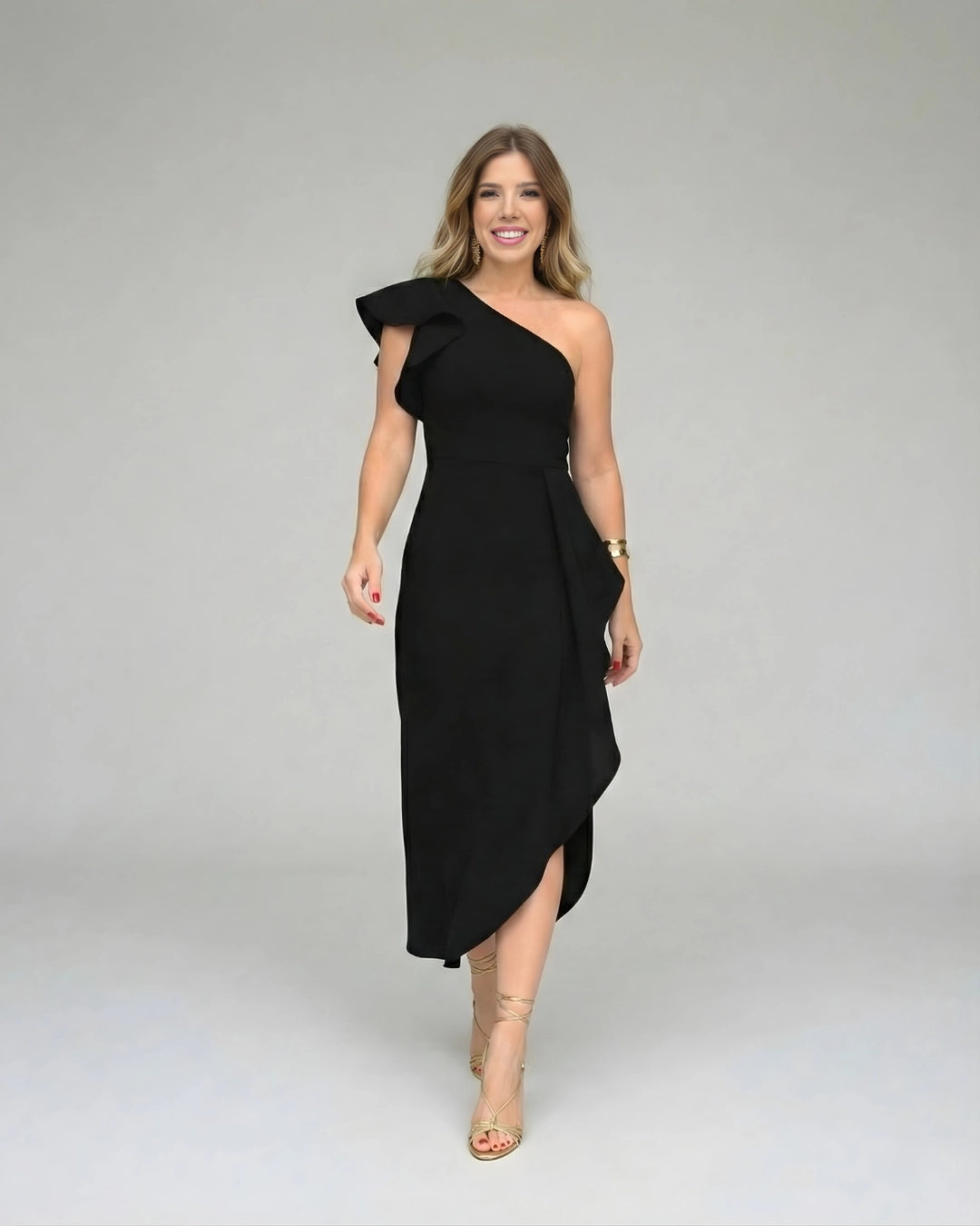Vestido de Festa Longo Preto Um Ombro Só de frente, com os braços soltos, mostrando o caimento assimétrico da saia
