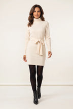 Vestido de Malha Gola Alta com Cinto Creme - modelo caminhando, dando um passo à frente