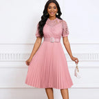 Vestido de Renda Longo Plissado Sofia na cor rosé, visto de frente com corpete de renda vazada, cinto e saia plissada