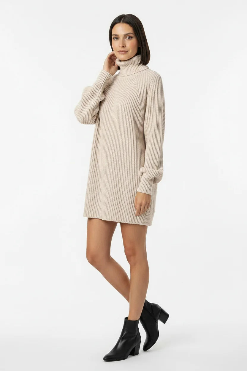 Vestido de Tricot Oversized Gola Alta Bege visto de perfil, com meia-calça preta e bota de cano curto