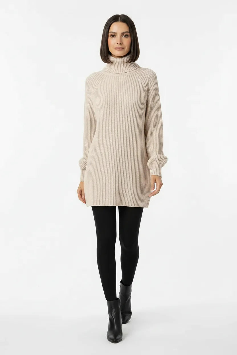 Vestido de Tricot Oversized Gola Alta Bege visto de frente, com meia-calça preta e bota preta de cano curto