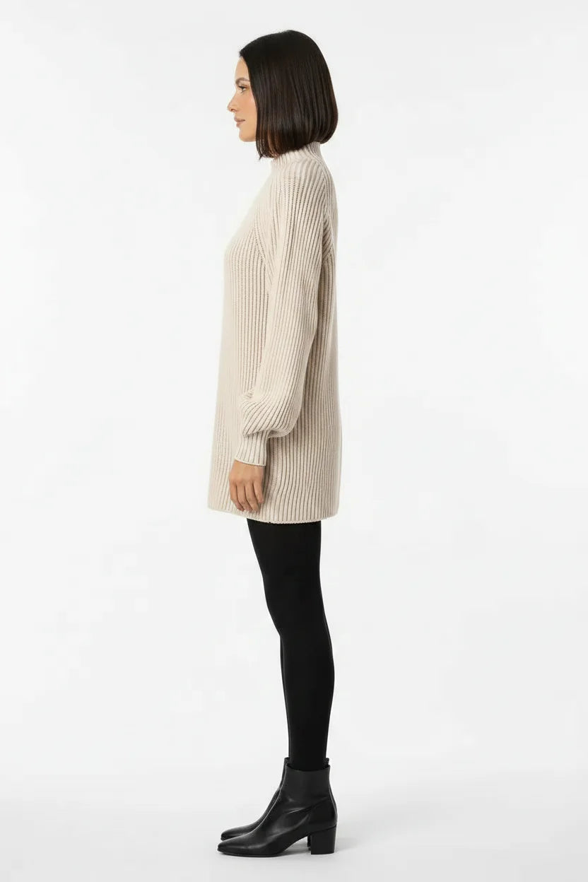 Vestido de Tricot Oversized Gola Alta Bege visto de lado, com as mangas amplas e o comprimento acima do joelho