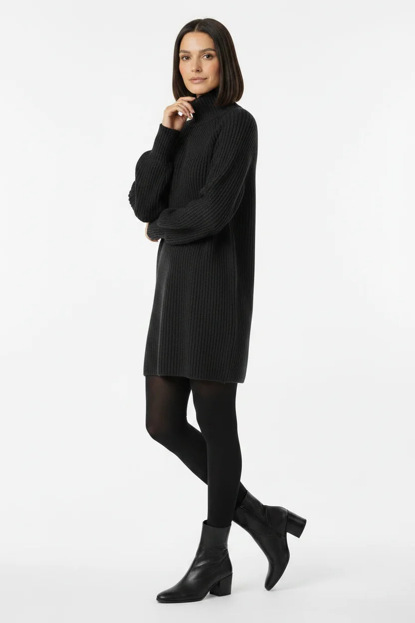 Vestido de Tricot Oversized Gola Alta Grafite em pose de três quartos, com os braços cruzados