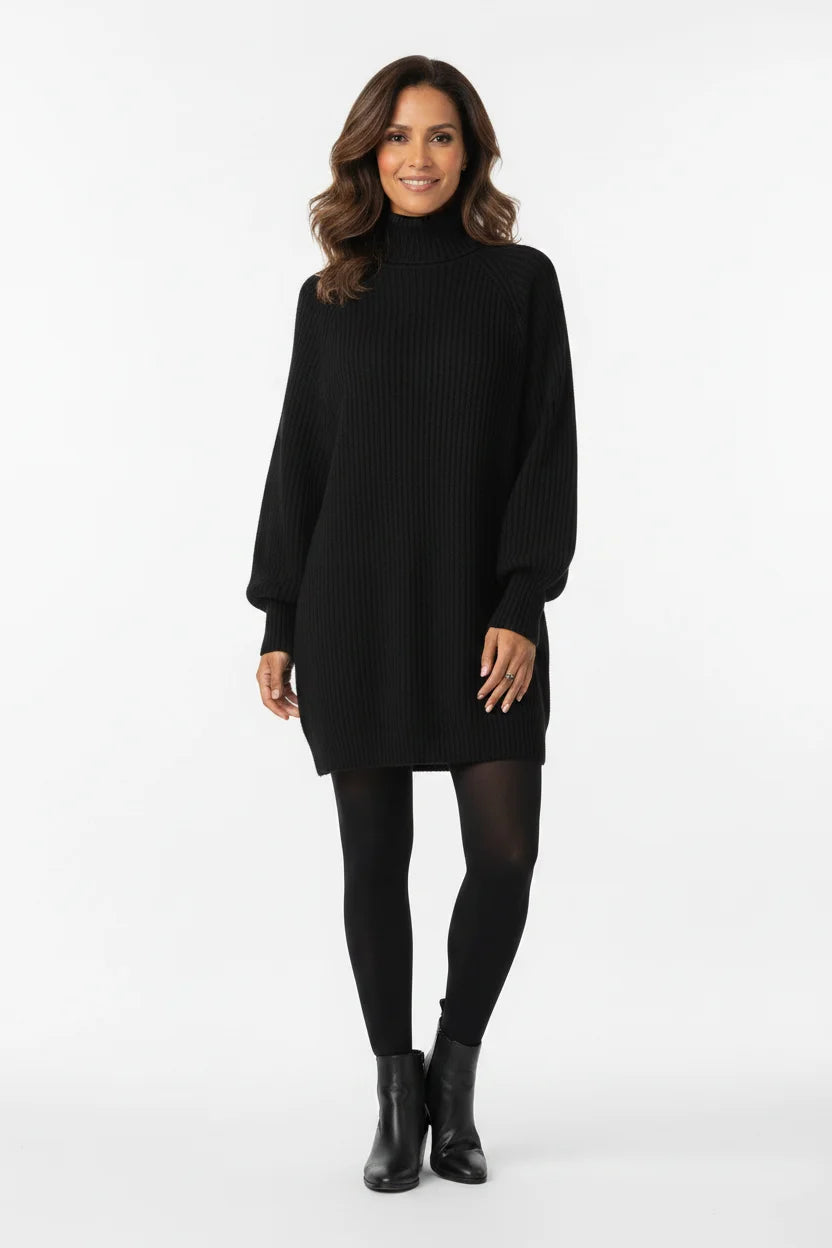 Vestido de Tricot Oversized Gola Alta Preto visto de frente, com meia-calça preta e bota de cano curto