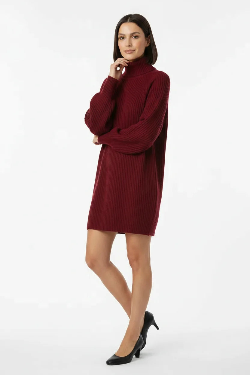 Vestido de Tricot Oversized Gola Alta Vinho em pose de três quartos, com a mão junto ao rosto e scarpin preto