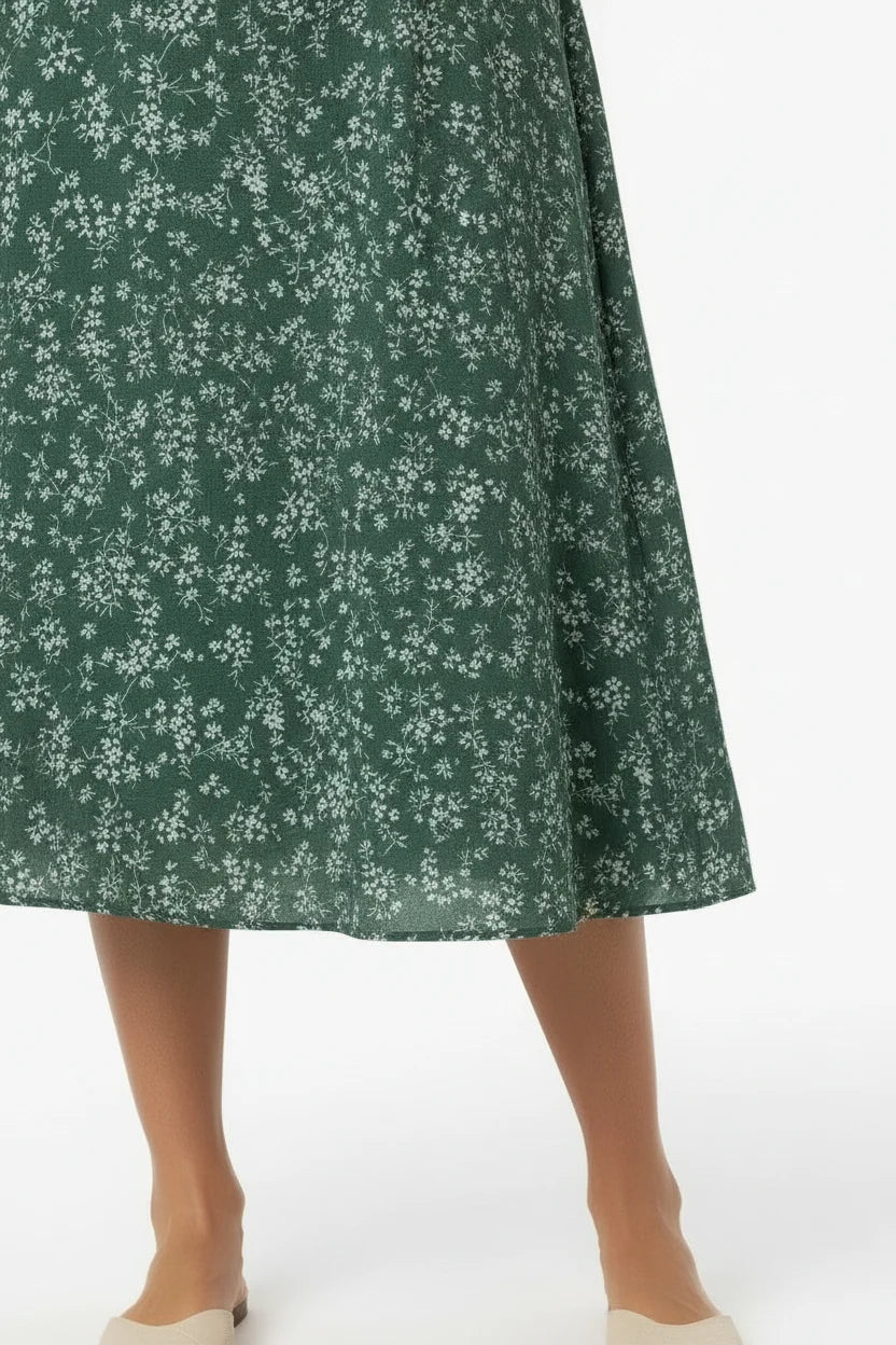 Vestido Feminino Longo Manga 3/4 Florido Verde em close da barra, mostrando o comprimento midi e o caimento do tecido