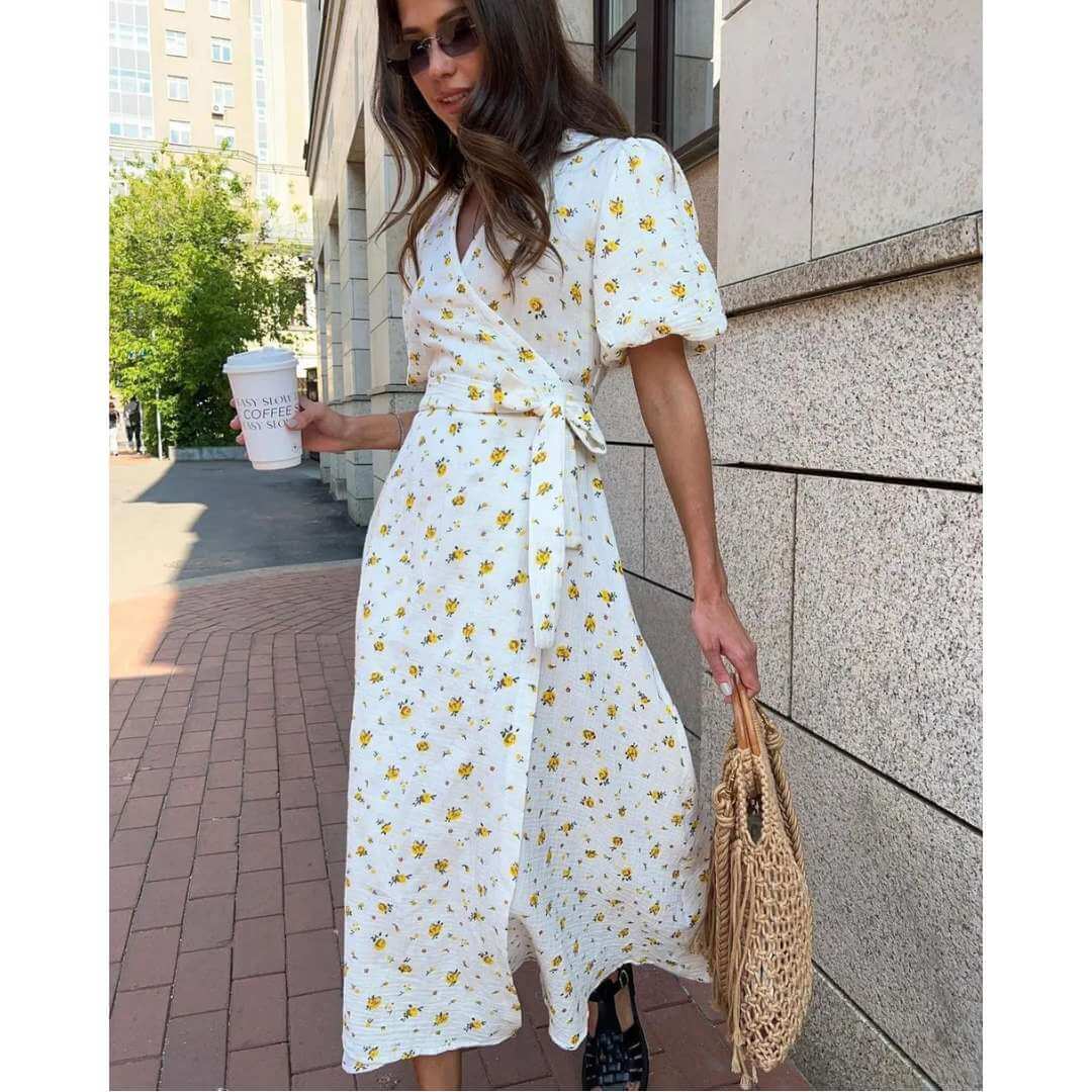 Vestido Feminino Midi Florido Amarelo visto de perfil, mostrando o transpasse e o laço lateral da faixa