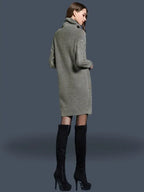 Vestido Feminino Suéter Gola Alta Inverno cinza mescla, visto de costas com a trança na manga em destaque e bota preta acima do joelho