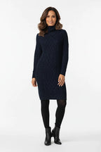 Vestido Feminino Suéter Gola Alta Inverno azul-marinho, visto de frente com tricô trançado, meia-calça preta e bota de cano curto