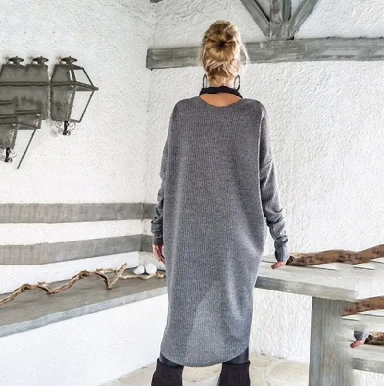 Vestido Feminino Suéter Manga Longa Inverno cinza, visto de costas em cena externa com o cabelo preso