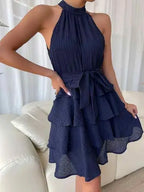 Vestido de Festa Curto Sem Manga Manuela Azul Marinho visto de frente, com gola halter, faixa na cintura e saia em camadas