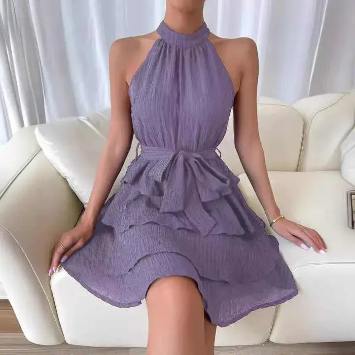 Vestido de Festa Curto Sem Manga Manuela Lilás com a modelo sentada, mostrando o caimento suave das camadas