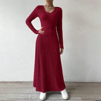 Vestido Longo de Malha Manga Longa Vermelho de frente com a mão na cintura, evidenciando a malha canelada
