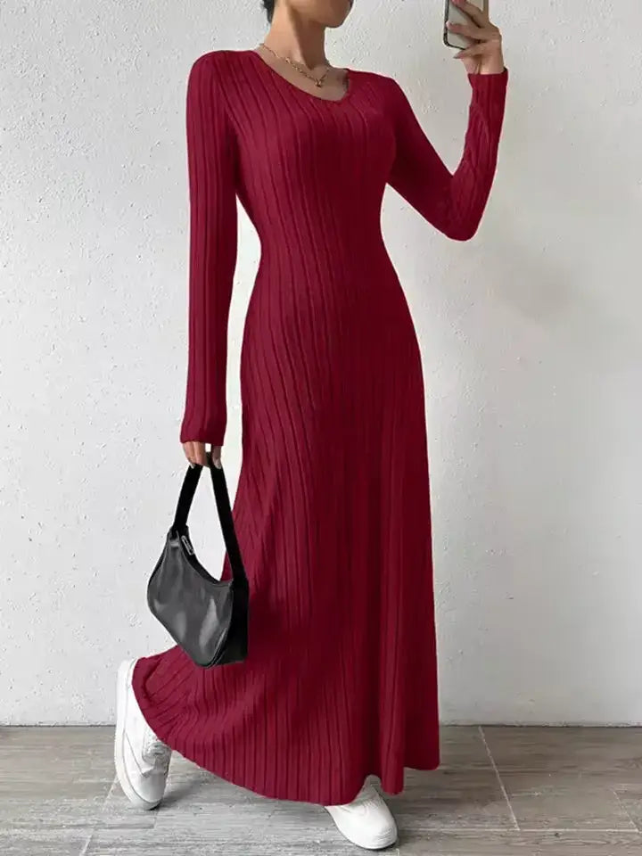 Vestido Longo de Malha Manga Longa Vermelho com bolsa preta na mão e tênis branco, em look casual
