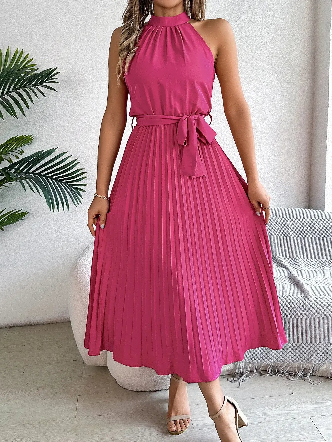 Vestido Longo Plissado Sem Mangas Anna na cor pink, visto de frente com laço na cintura e sandália nude