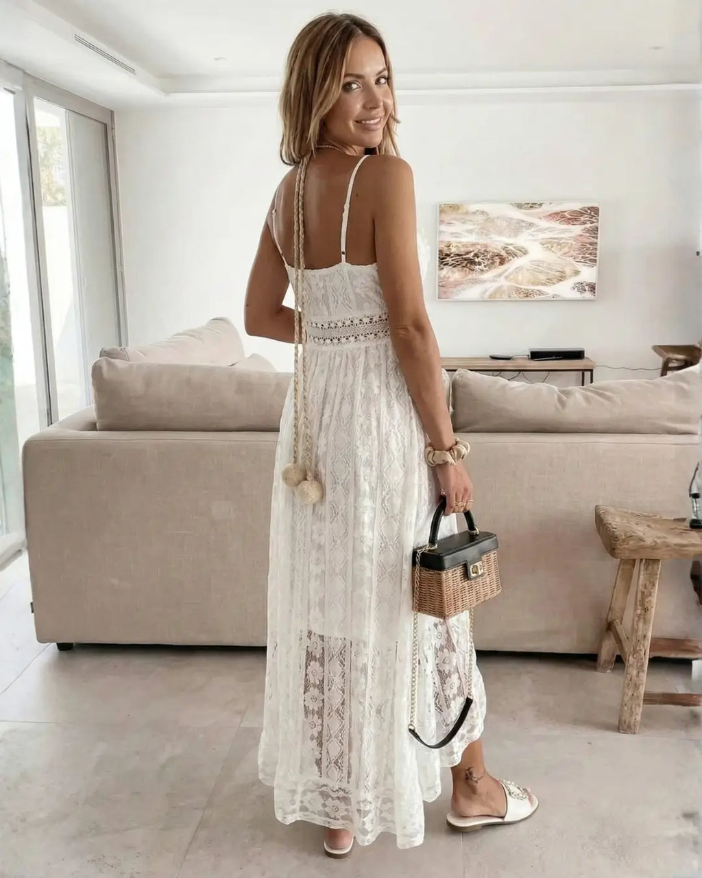 Vestido Feminino Longo de Renda Off White Estilo Boho Chic visto de costas, mostrando o decote nas costas e o babado da barra