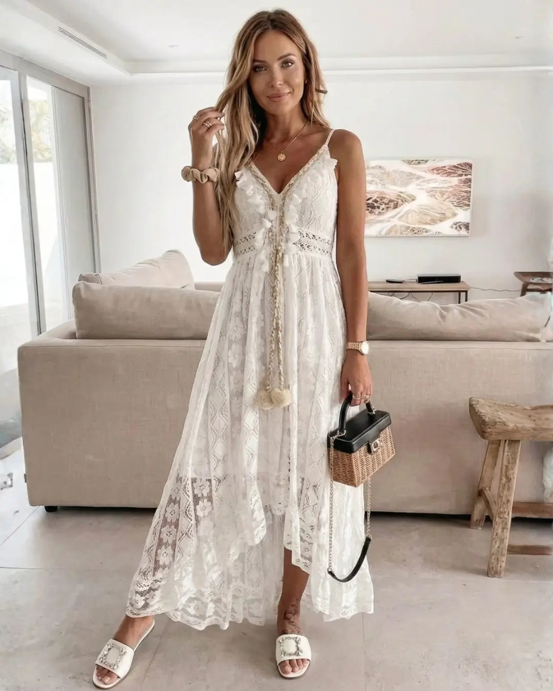 Vestido Feminino Longo de Renda Off White Estilo Boho Chic com a modelo ajeitando o cabelo, mostrando as alças e o decote em V