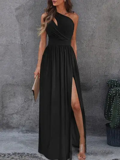 Vestido Longo Um Ombro Só com Fenda preto, visto de frente com transpasse no busto, fenda alta e clutch nude