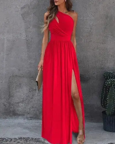Vestido Longo Um Ombro Só com Fenda na cor vermelha, visto de frente com fenda alta e clutch nude