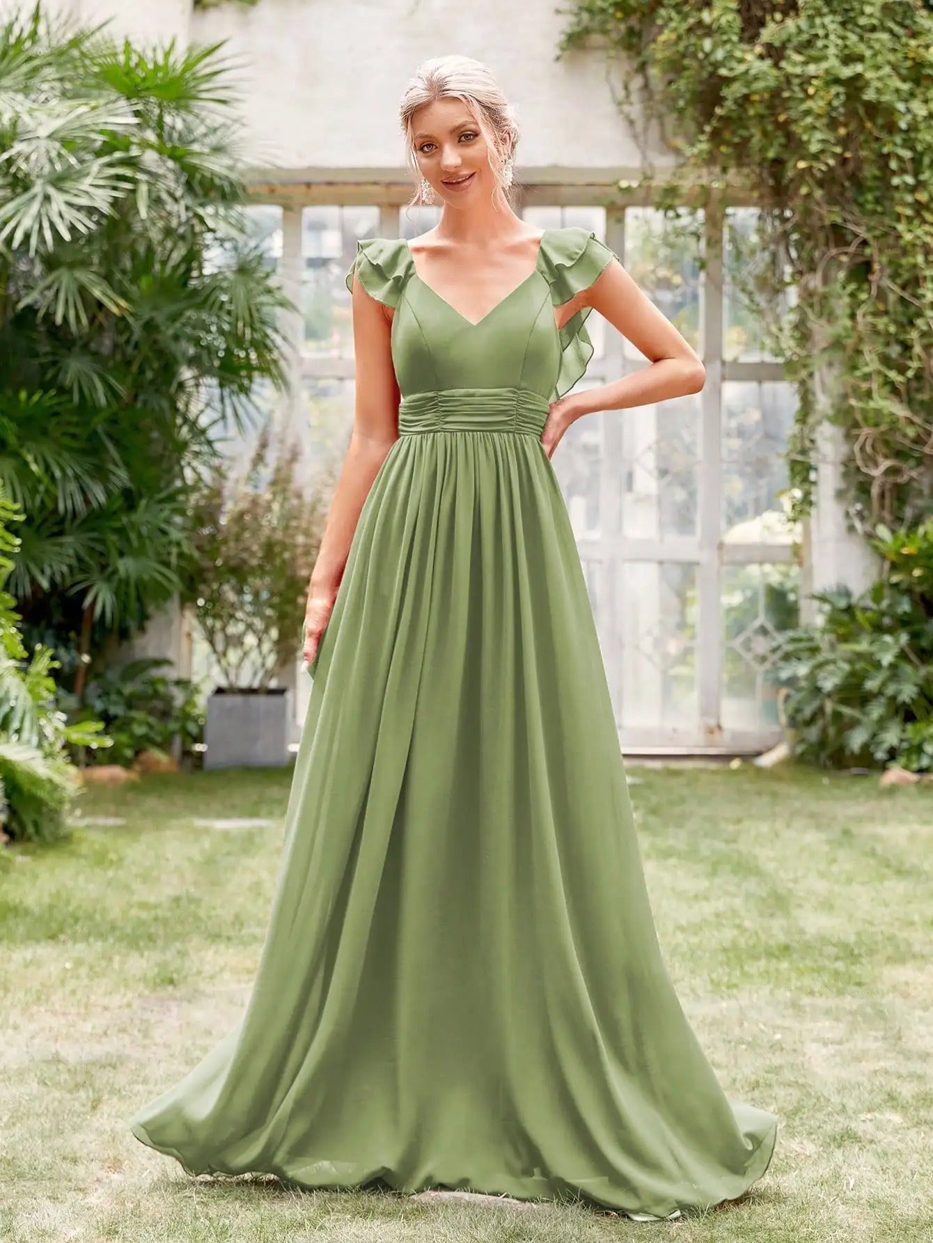 Vestido Longo Verde Fluido com Decote em V e Mangas de Babado de frente com a mão na cintura, mostrando o caimento fluido