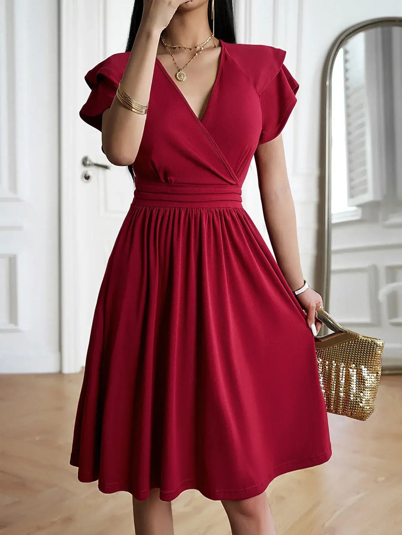 Vestido Midi Decote V Jade Vermelho em plano aproximado, destacando o babado da manga e os colares sobrepostos