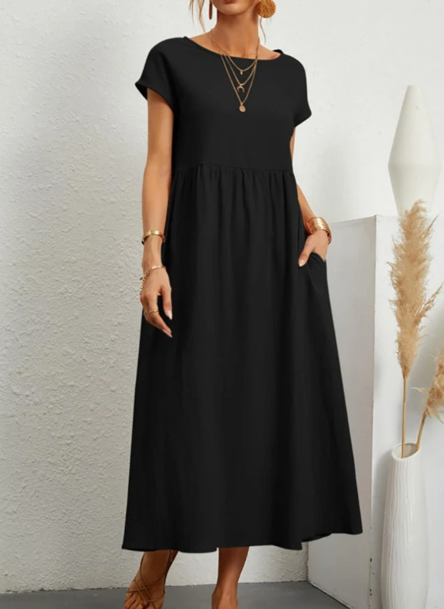 Vestido Midi Feminino Preto de Algodão e Linho Estilo Vintage com Bolsos de frente, destacando o decote redondo e a manga curta