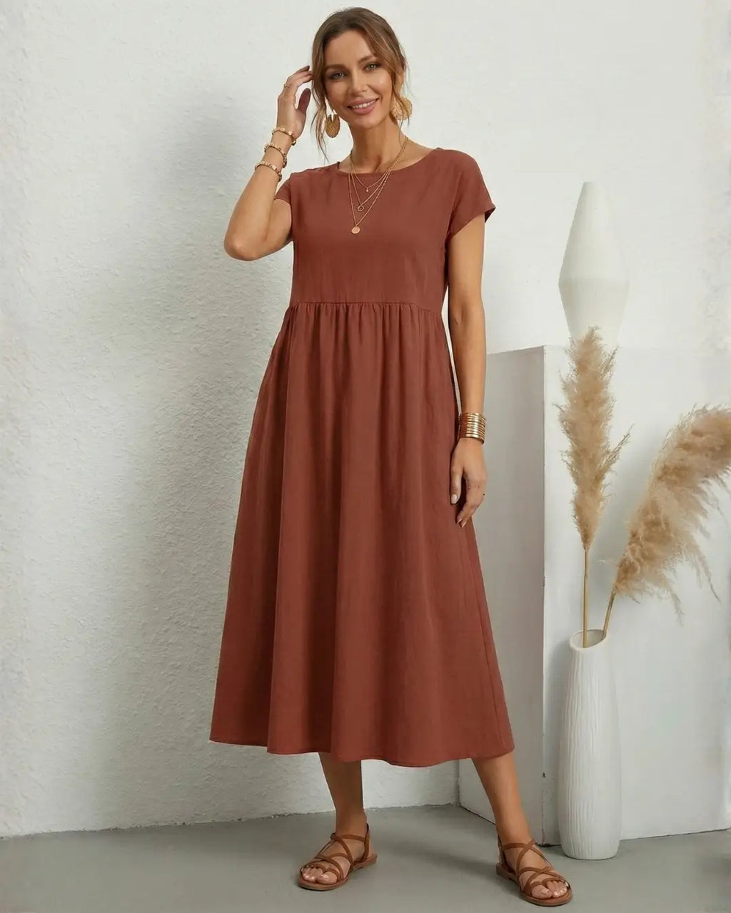 Vestido Midi Feminino Terracota em Algodão e Linho Estilo Boho com Bolsos com a modelo ajeitando o cabelo, mostrando o caimento