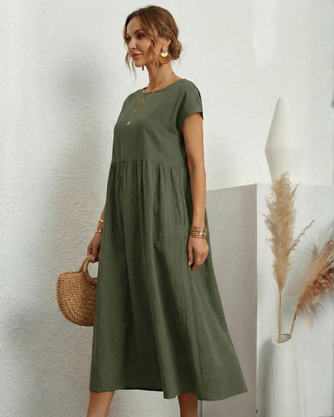 Vestido Midi Verde Oliva em Linho e Algodão em pose de três quartos, evidenciando o caimento amplo do linho