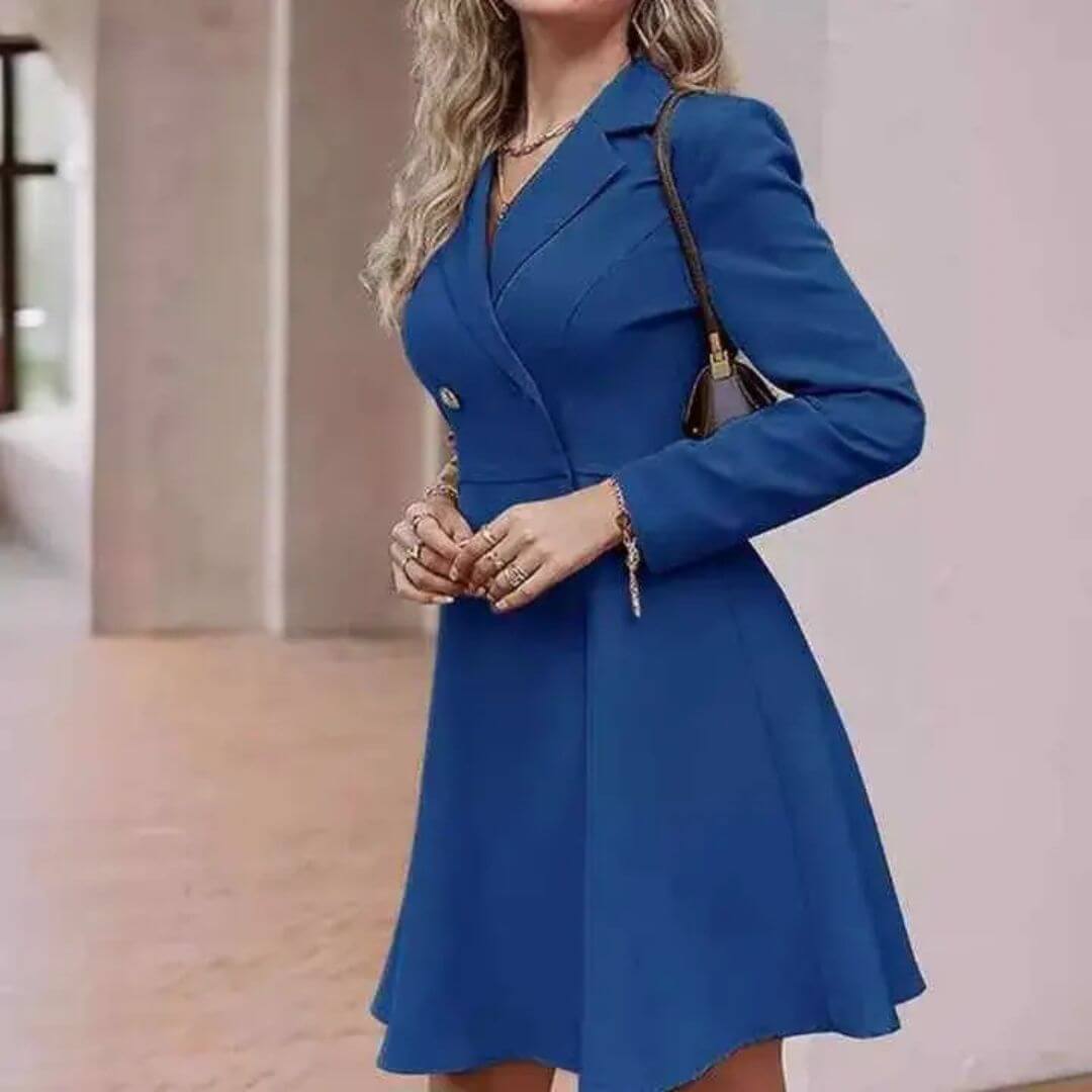 Vestido Tipo Blazer Manga Longa Mariana Azul em cena interna, com bolsa de alça corrente e a saia rodada