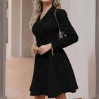Vestido Tipo Blazer Manga Longa Mariana Preto em cena interna, com bolsa de alça corrente e saia evasê