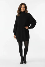 Vestido de Tricot Oversized Gola Alta Preto de frente com a mao no quadril, mostrando o comprimento