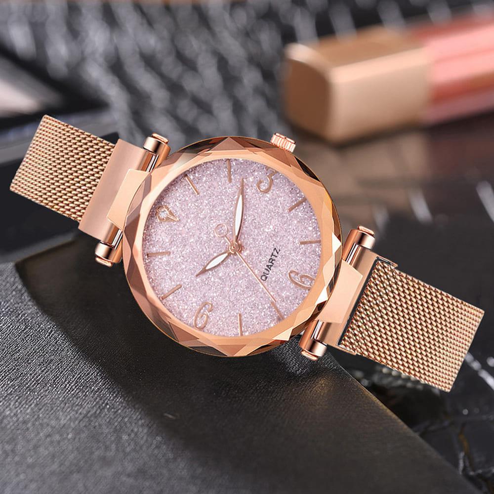 Relógio de Pulso Feminino Céu Estrelado Rosé Gold apoiado em superfície escura, destacando o mostrador com brilho e o aro facetado